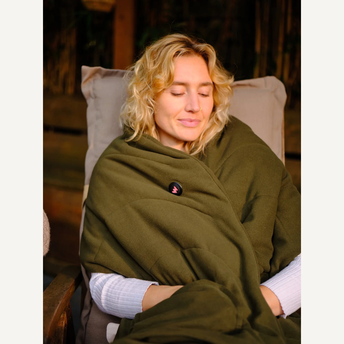 WAHRM draadloze verwarmde dames shawl donkergroen, blond model ontspannen zittend