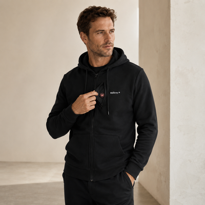 Man draagt de zwarte WAHRM Sam verwarmde hoodie met rits